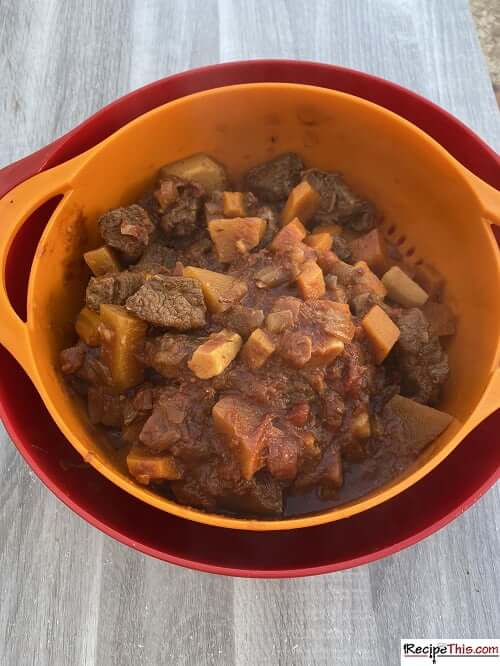 straining the excess liquid from the beef stew